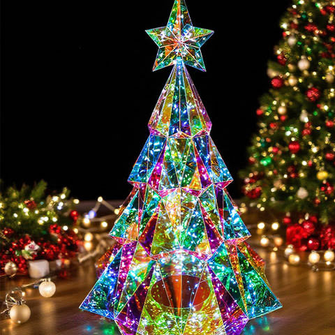 The holographic tree with its star lit up beside a Christmas tree