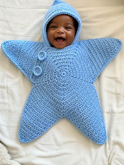 Hand-crocheted starfish suit in Sky Blue, on a baby