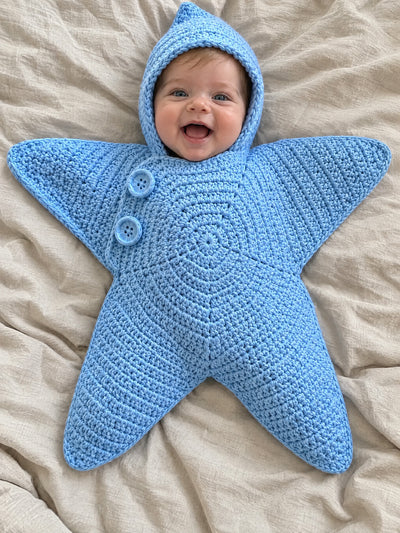 Hand-crocheted starfish suit in Sky Blue, on a baby